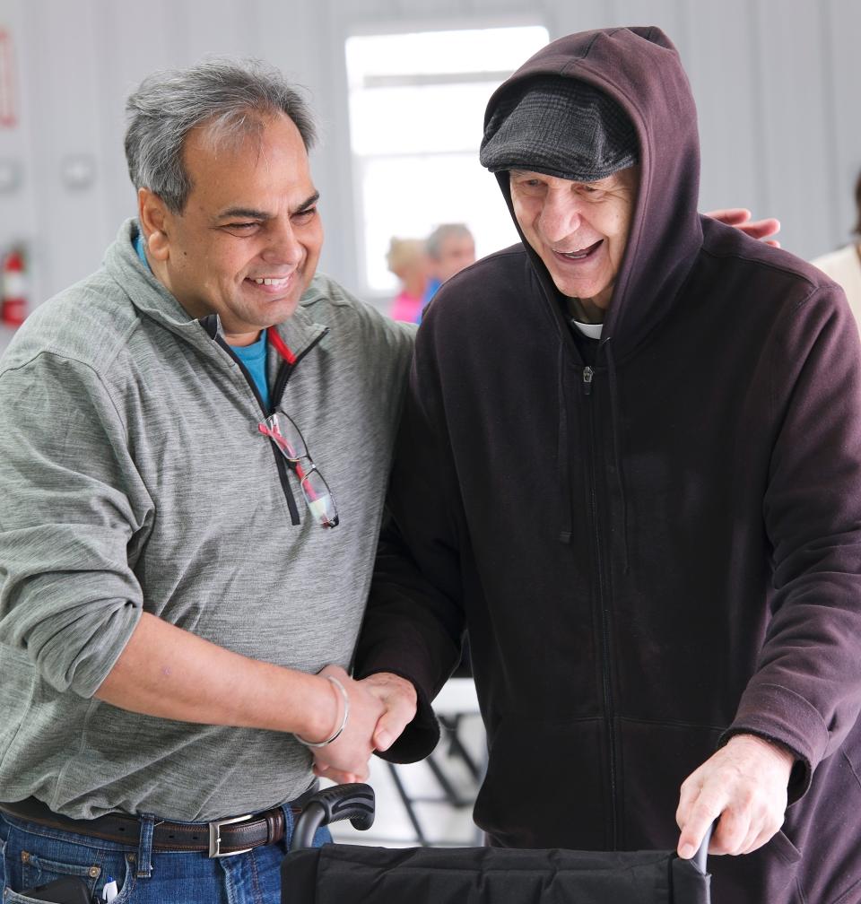 Amit Gumman, left, greets the Rev. Paul Zahler, a Benedictine monk and Catholic priest who started the camps at St. Gregory's University in Shawnee several decades ago. Camp Benedictine was having its spring camp for individuals with special needs at its new facility in McLoud.