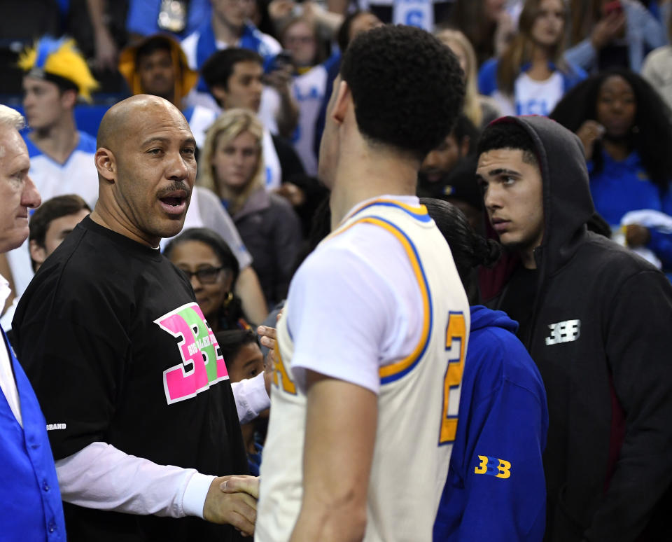 In this March 4, 2017, file photo, UCLA guard Lonzo Ball, right, shakes hands with his father LaVar following an NCAA college basketball game against Washington State in Los Angeles. UCLA won 77-68. LaVar Ball told Southern California News Group for a story published online on April 6, 2017, that UCLA was eliminated in the NCAA tournament because “three white guys” couldn’t pick up the slack after his son suffered a hamstring injury. (AP Photo/Mark J. Terrill, File)