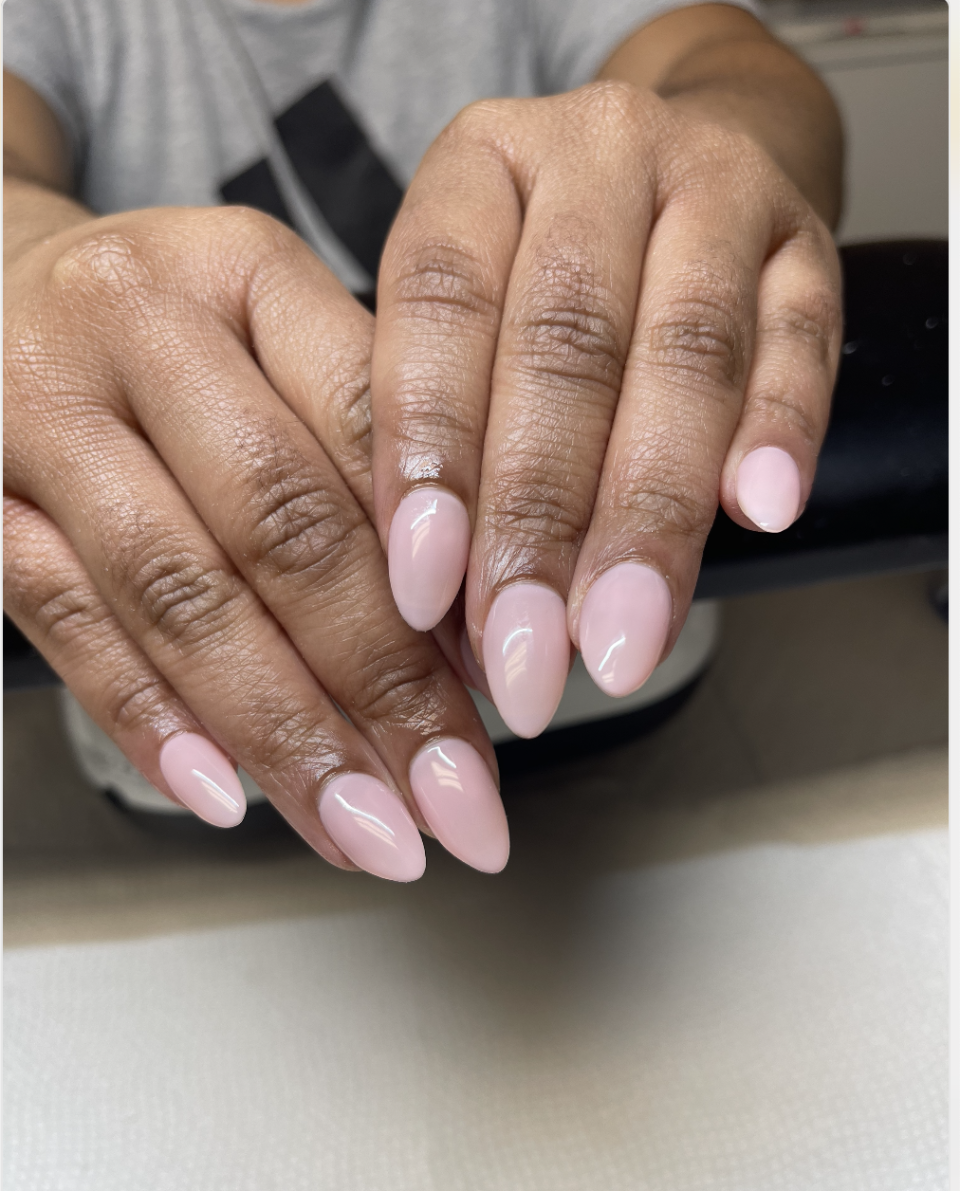 Close-up of a person's hands showing their pink manicured nails