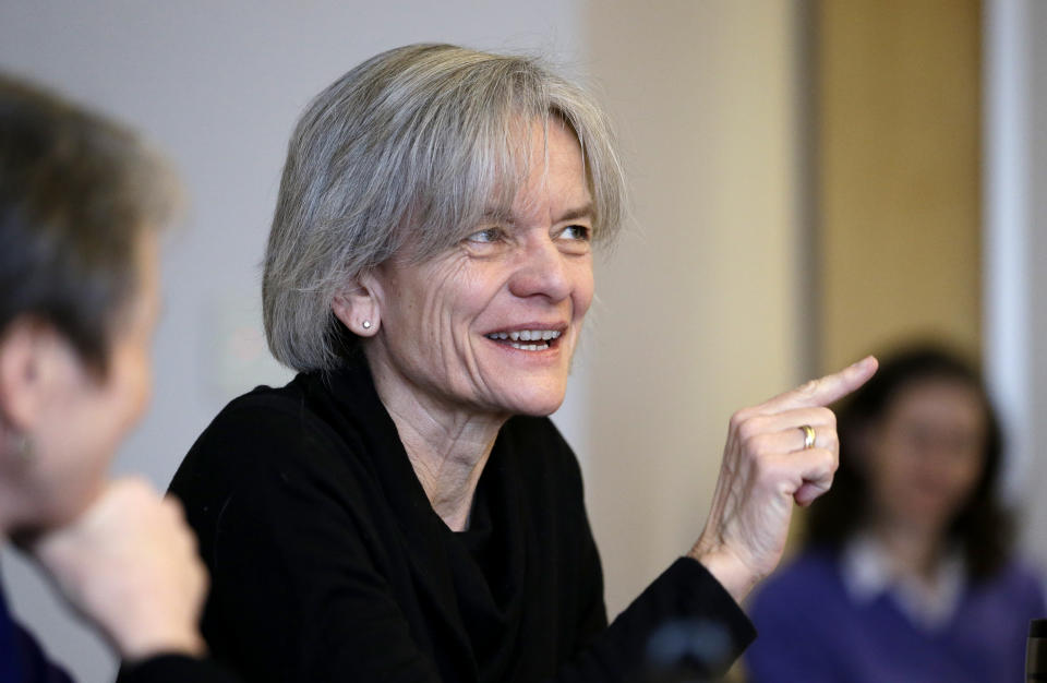 Lisa Graumlich sits at a table as she speaks during a discussion at the University of Washington.