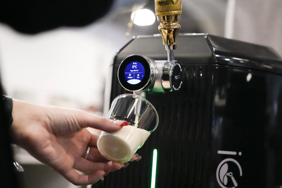 Natalie Sanchez, IGulu, pours a glass of beer made in the IGulu F1 automated home brewing machine during the CES tech show Wednesday, Jan. 10, 2024, in Las Vegas. (AP Photo/Ryan Sun)