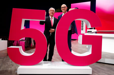 Timotheus Hoettges, CEO of Deutsche Telekom AG and Ulrich Lehner, chairman of the supervisory board, pose behind a 5G logo during the company's annual shareholders meeting in Bonn, Germany March 28, 2019. REUTERS/Wolfgang Rattay