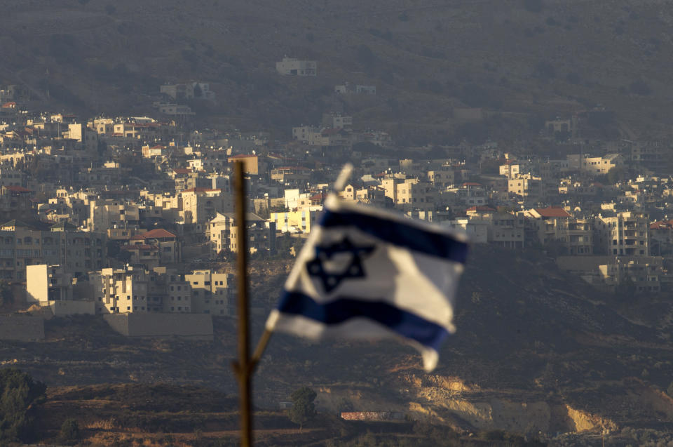 FILE - In this file photo dated Thursday, Oct. 11, 2018, an Israeli flag in front of the village of Majdal Shams in the Israeli-controlled Golan Heights. Syria slammed President Donald Trump's abrupt declaration that Washington will recognise Israel's sovereignty over the Israeli-occupied Golan Heights, saying Friday March 22, 2019, the statement was "irresponsible" and a threat to international peace and stability. (AP Photo/Ariel Schalit, FILE)