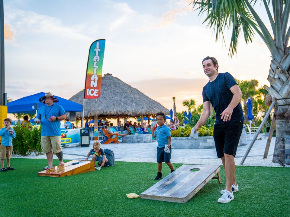 People playing corn hole at sunset at Camp Margaritaville in Auburndale, Florida.