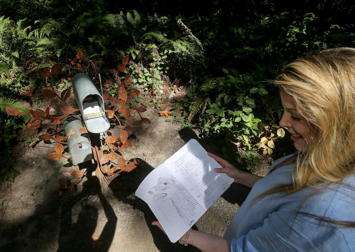 Denise Stoughton flips through the latest journal from the Kindred Spirit mailbox located in Bainbridge Island’s Fort Ward Park on Sept. 14.