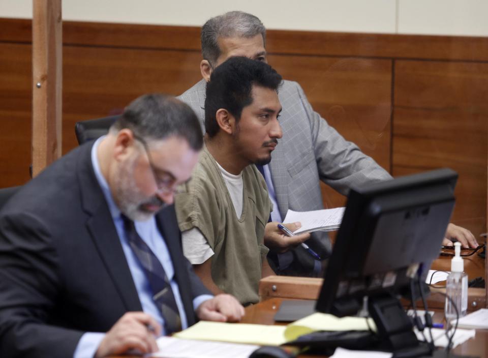 Gerson Fuentes, center, accused of raping a 9-year-old girl who then traveled to Indiana after she turned 10 to have an abortion, appears between his attorney, Bryan Bowen, left, and an interpreter in Franklin County common pleas court for his bond hearing in Columbus, Ohio.