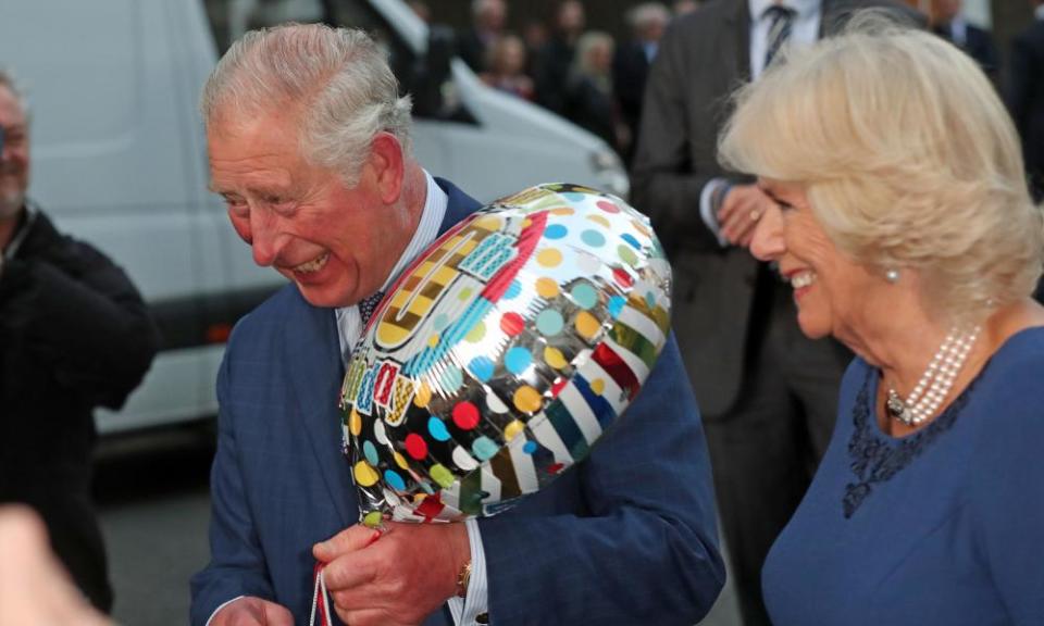 The Prince of Wales holds a birthday gift accompanied by the Duchess of Cornwall