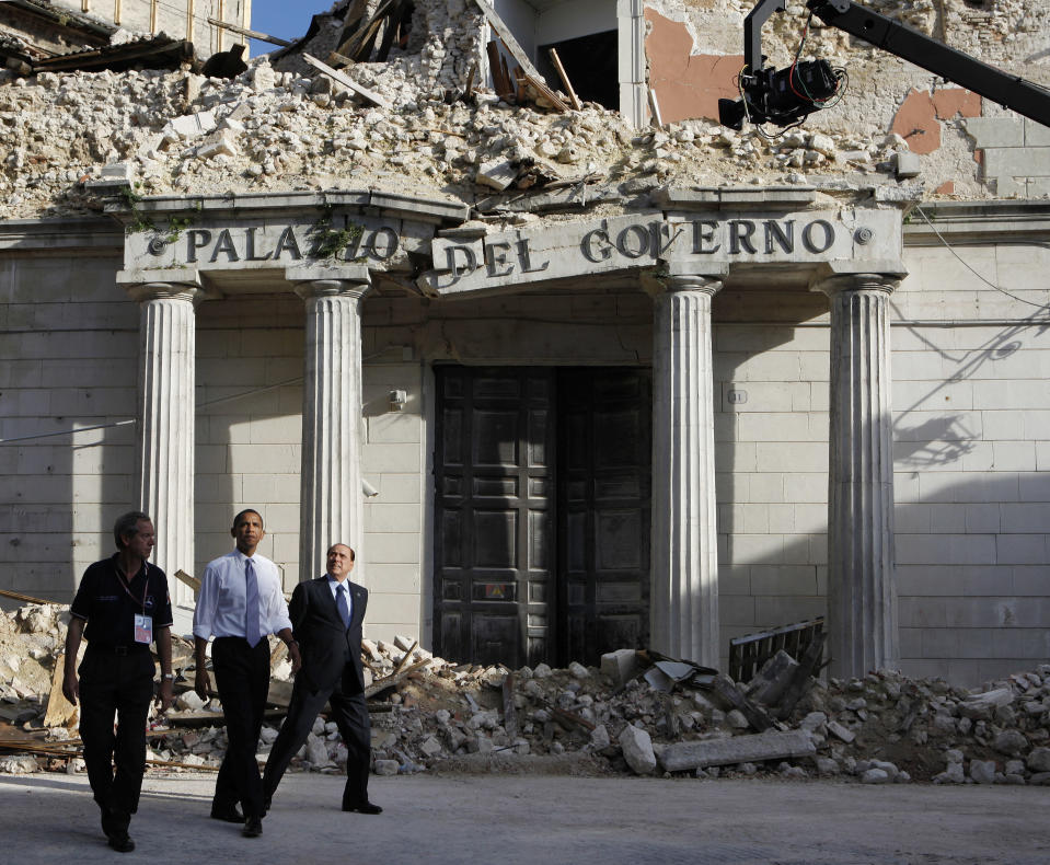FILE - In this July 8, 2009 file photo U.S. President Barack Obama and Italy's Prime Minister Silvio Berlusconi, right, with an unidentified official, tour earthquake damage on the sidelines of the G8 Summit in L'Aquila, Italy. Berlusconi, the boastful billionaire media mogul who was Italy's longest-serving premier despite scandals over his sex-fueled parties and allegations of corruption, died, according to Italian media. He was 86. (AP Photo/Charles Dharapak, File)