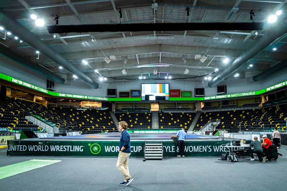Staffer work to set up for the UWW Freestyle and Women’s World Cup on Wednesday at Xtream Arena in Coralville.