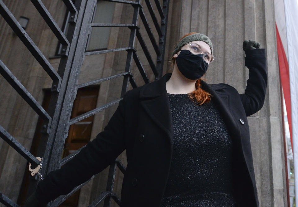 A women is handcuffed to the gate in front of the Education Ministry building in Warsaw, Poland, on Monday Nov. 23, 2020. Police detained several people as women-led protests over abortion rights flared up again in Warsaw and elsewhere in Poland. The protests, organized by the group Women's Strike, have been occurring regularly ever since the country's constitutional court issued an Oct. 22 ruling that further tightens an abortion law that was already one of the most restrictive in Poland.(AP Photo/Czarek Sokolowski)