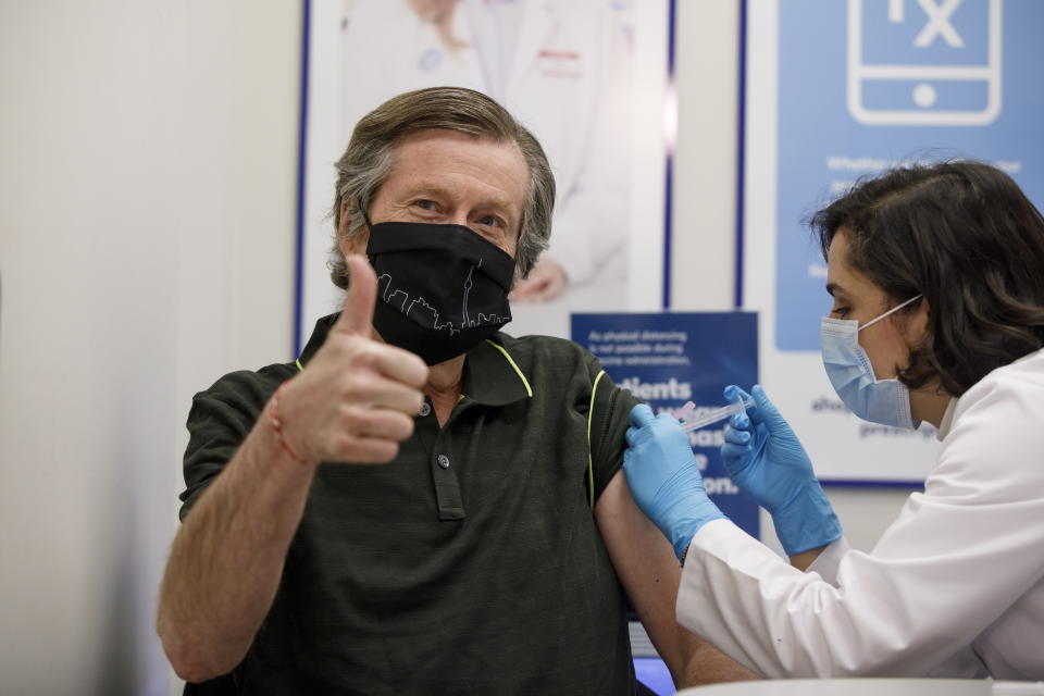 Toronto Mayor John Tory receives a dose of the AstraZeneca COVID-19 vaccine by pharmacist Niloo Saiy at a Shoppers Drug Mart pharmacy in Toronto, Saturday, April 10, 2021. (Cole Burston/The Canadian Press via AP)