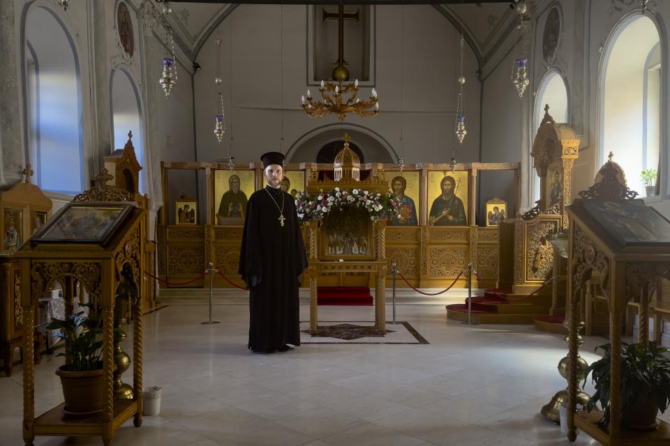 The Rev. Ioann Koval stands inside an old Orthodox church in Antalya, Turkey, Sunday, July 16, 2023. The Koval started serving in this church after the Russian Orthodox Church leadership decided to defrock him following his prayer for peace in Ukraine. Koval, who used to serve in a church in Moscow, appealed the decision to Ecumenical Patriarch Bartholomew of Constantinople, and the Constantinople ruled to restore his holy rank, allowing him to serve in one of its churches. (AP Photo/Kostya Manenkov)