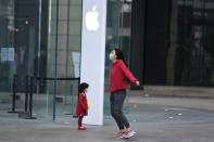 People wear face masks in front of an Apple Store, as the country is hit by an outbreak of the novel coronavirus, in Kunming, Yunnan