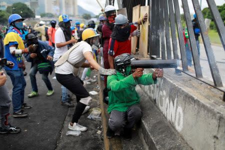 A demonstrator fires a home made weapon while clashing with riot security forces in the perimeter of an Air Force base during a rally against Venezuela's President Nicolas Maduro's Government in Caracas, Venezuela, June 24, 2017. REUTERS/Marco Bello