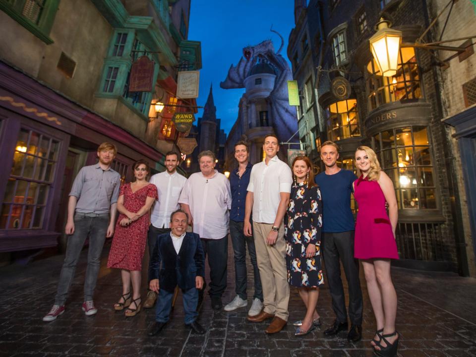 Cast members from "Harry Potter" pose for a group photo at the Diagon Alley section of The Wizarding World of Harry Potter