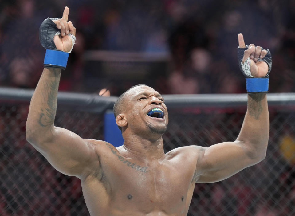 May 13, 2023; Charlotte, North Carolina, USA; Jailton Almeida (blue gloves) reacts after defeating Jairzinho Rozenstruik (red gloves) in a heavyweight bout during UFC Fight Night at Spectrum Center. Mandatory Credit: Jim Dedmon-USA TODAY Sports