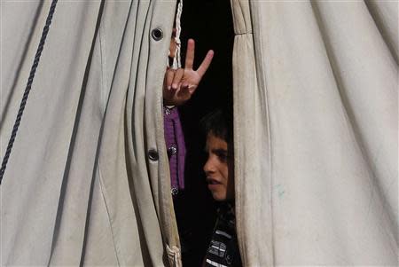 A Syrian refugee child who arrived from Damascus, gestures in a tent at the Majdal Anjar refugee camp in Bekaa Valley near the Syrian border in eastern Lebanon, September 9, 2013. REUTERS/Jamal Saidi