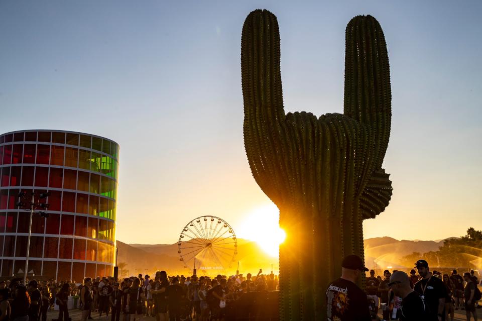 The rocker cactus sculpture is seen with Spectra and the Ferris wheel in the background as the sun sets behind the mountains at Power Trip Music Festival at the Empire Polo Club in Indio, Calif., Sunday, Oct. 8, 2023.