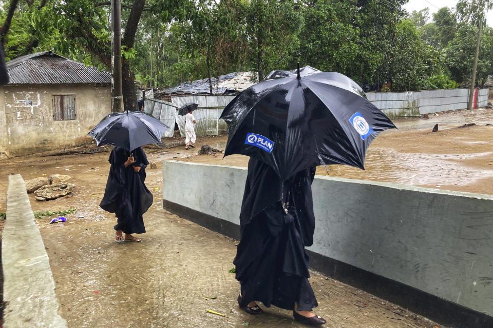 Women arrive at a makeshift shelter set up for residents of coastal areas, in Teknaf, near Cox's Bazar, Bangladesh, Sunday, May 14, 2023. Bangladesh and Myanmar braced Sunday as a severe cyclone started to hit coastal areas and authorities urged thousands of people in both countries to seek shelter. (AP Photo/Al-emrun Garjon)