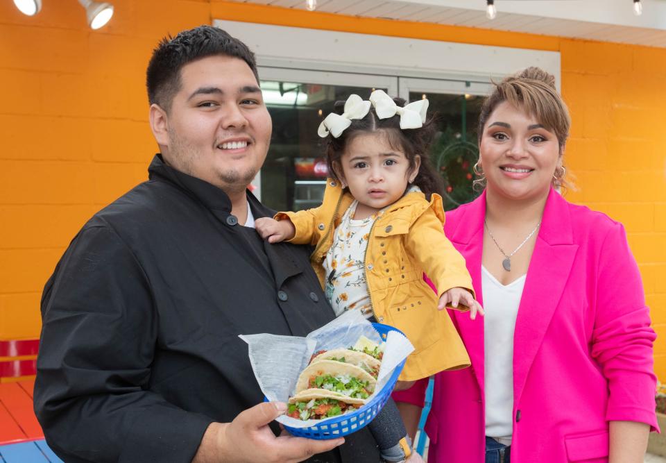 Owners Giovanny Lopez, left, and Lesly Campos pose with their daughter Haylee, 1, and an order of Tacos Alpastor at the new Pollos El Gordo Mexican restaurant at 3670 Barrancas Avenue in Pensacola on Monday, Nov. 13, 2023.