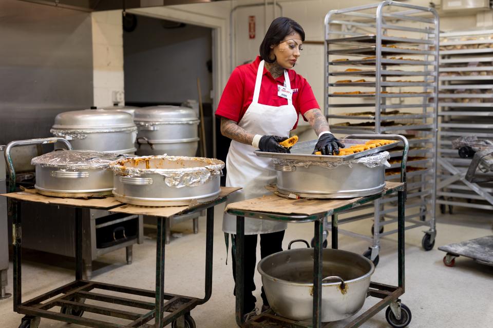 María Treviño, an employee at Food City Supermarket in El Paso arranges the red pork tamales on trays to cool off after they have been steamed on Tuesday, Dec. 19, 2023.