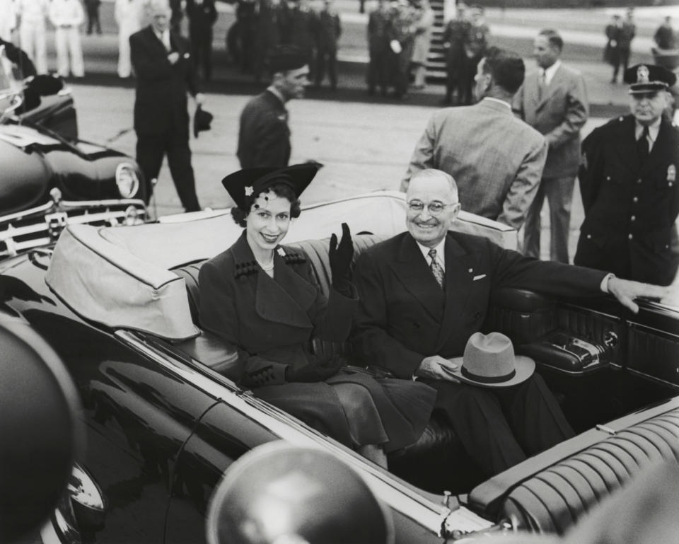 Queen Elizabeth II, beaming, rides in an open car with President Harry Truman. (NARA)