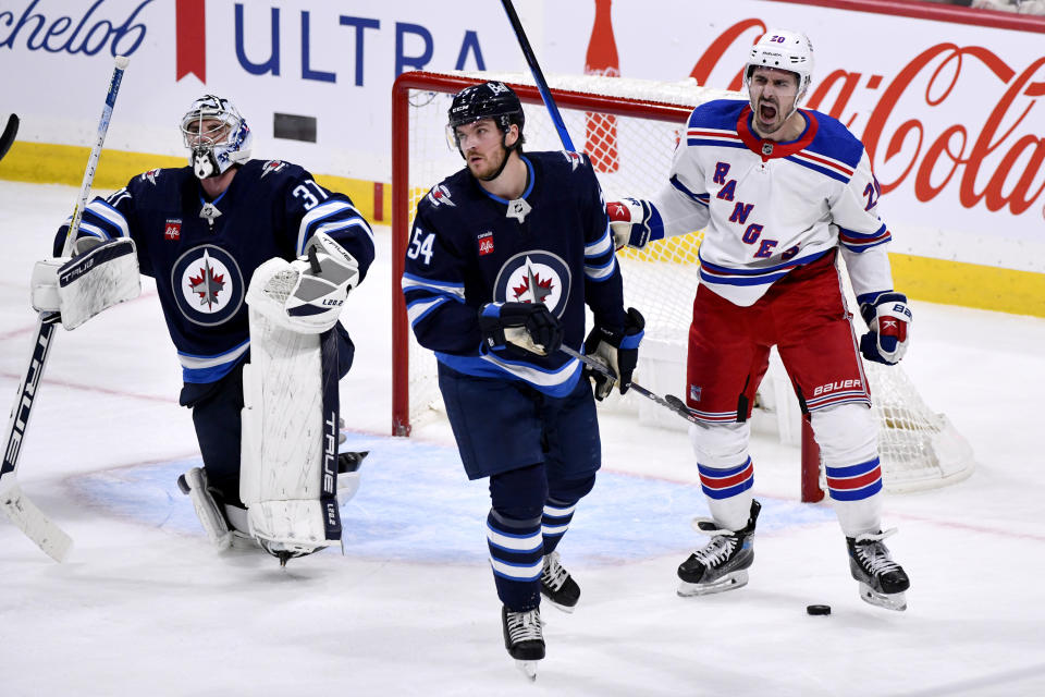 New York Rangers' Chris Kreider (20) celebrates after his goal against the Winnipeg Jets as Jets goaltender Connor Hellebuyck (37) and Dylan Samberg (54) look on during third-period NHL hockey game action in Winnipeg, Manitoba, Monday, Oct. 30, 2023. (Fred Greenslade/The Canadian Press via AP)