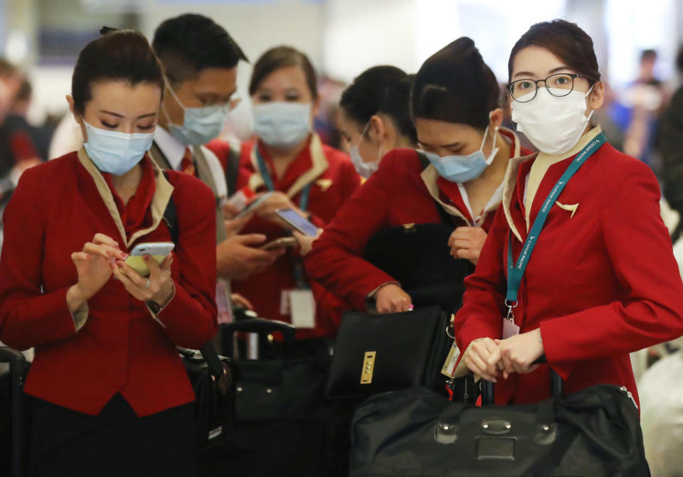 國泰可培訓一班有保險牌的空姐，在氣流中給乘客講解意外保險