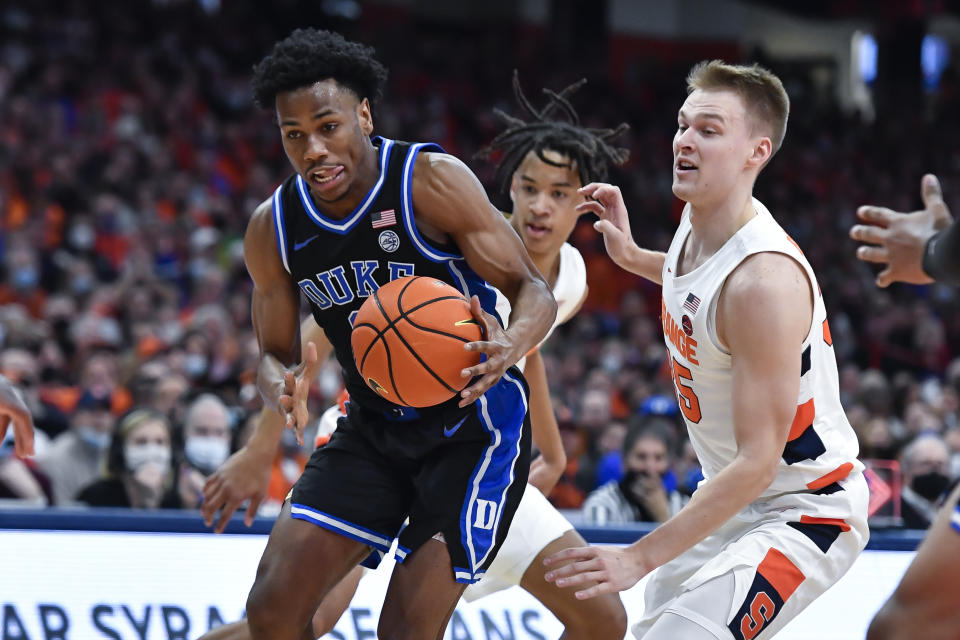 Duke guard Jeremy Roach, left, drives past Syracuse guard Buddy Boeheim during the first half of an NCAA college basketball game in Syracuse, N.Y., Saturday, Feb. 26, 2022. (AP Photo/Adrian Kraus)
