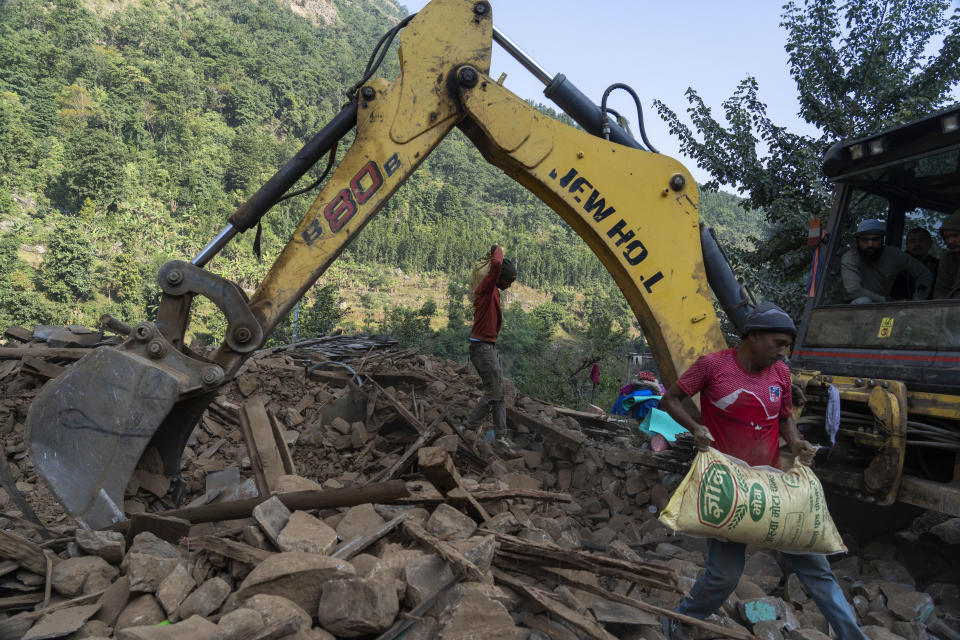 Survivors recover sacks of rice from earthquake damaged houses in Rukum District, northwestern Nepal, Monday, Nov. 6, 2023. The Friday night earthquake in the mountains of northwest Nepal killed more than 150 people and left thousands homeless. (AP Photo/Niranjan Shrestha)