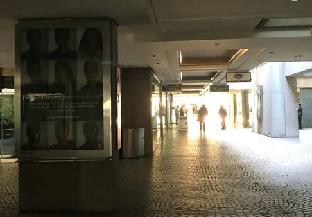 Customers walk through a darkened shopping mall during to a power cut in San Francisco, California, U.S. April 21, 2017. REUTERS/Alexandria Sage