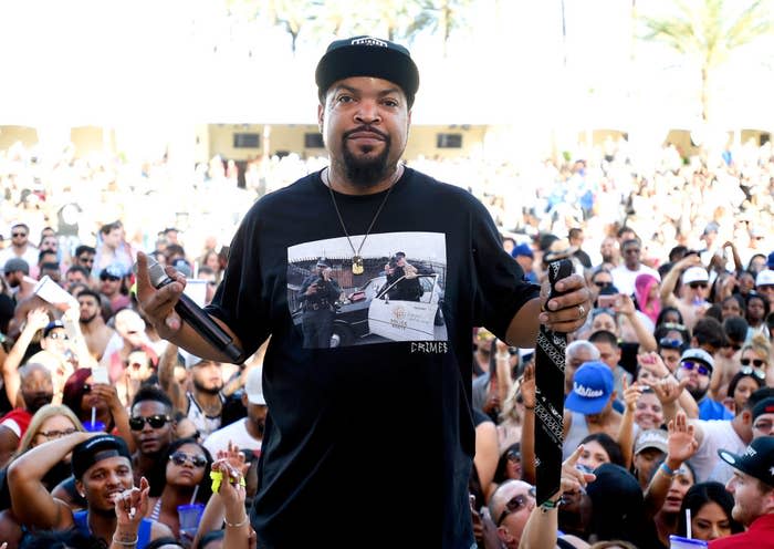 Ice Cube stands on stage with a crowd behind him