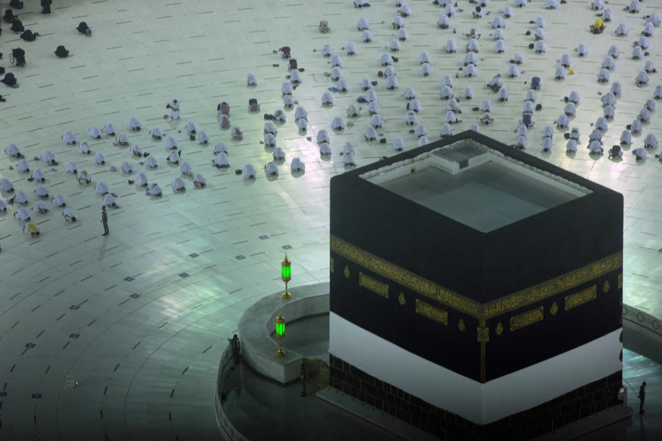 Muslim pilgrims pray in front of the Kaaba, the cubic building at the Grand Mosque, as they keep social distancing, at the start the annual hajj pilgrimage, Sunday, July 18, 2021. The pilgrimage to Mecca required once in a lifetime of every Muslim who can afford it and is physically able to make it, used to draw more than 2 million people. But for a second straight year it has been curtailed due to the coronavirus with only vaccinated people in Saudi Arabia able to participate. (AP Photo/Amr Nabil)