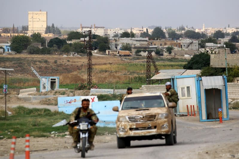 Buildings and houses are seen as Turkey-backed Syrian rebel fighters patrol near Ras al Ain Town