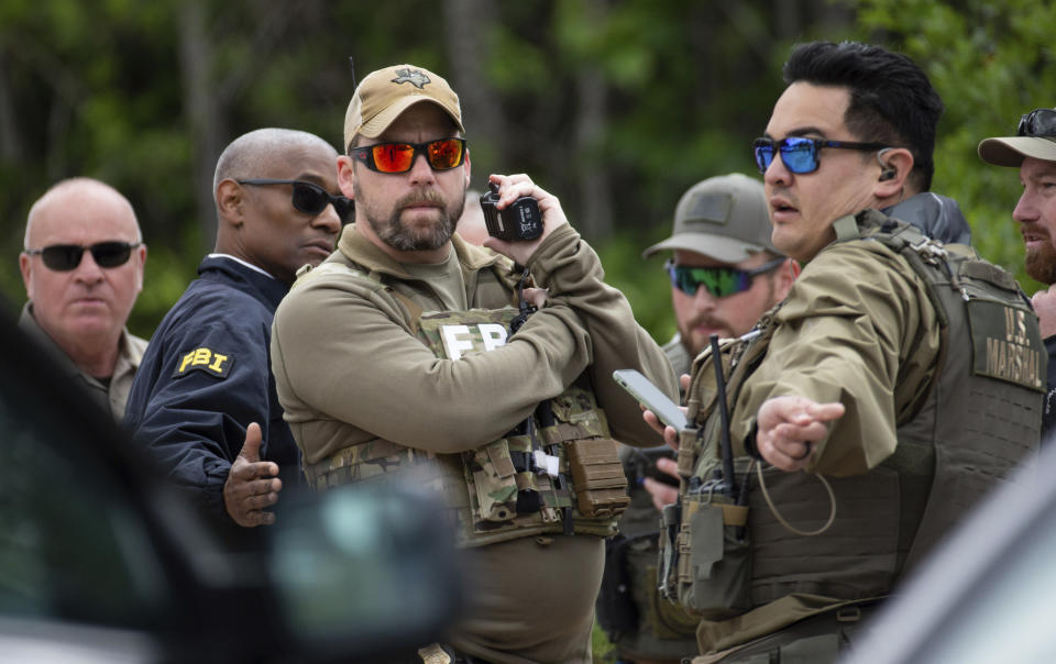 Authorities from multiple agencies work at a location where law enforcement believe they have cornered a suspect who allegedly shot and killed five people in a house the night before, Saturday, April 29, 2023, in unincorporated San Jacinto County, Texas. (Yi-Chin Lee/Houston Chronicle via AP)