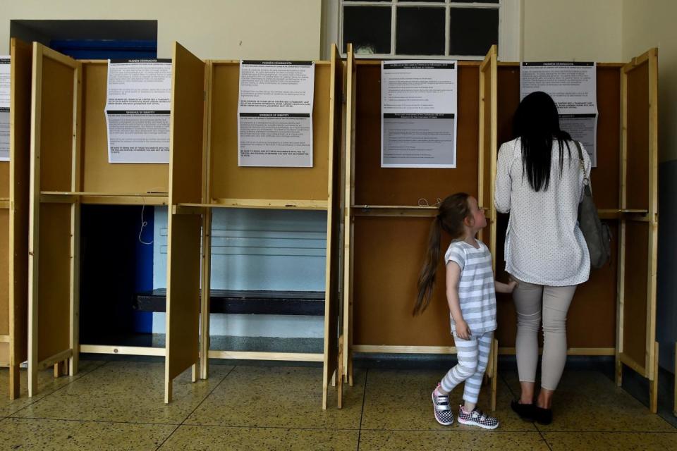 A woman casts her vote with her daughter in a polling station on Friday (REUTERS)