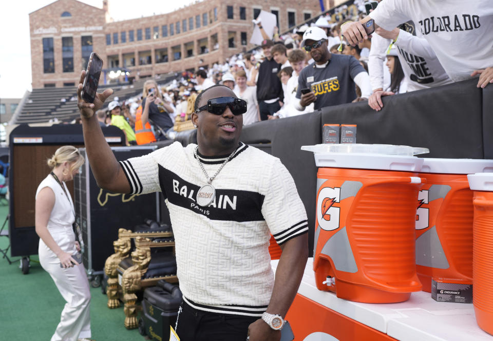 Retired NFL running back LeSean McCoy takes a photograph with his mobile device with fans as Colorado warms up to face Southern California in an NCAA college football game Saturday, Sept. 30, 2023, in Boulder, Colo. (AP Photo/David Zalubowski)