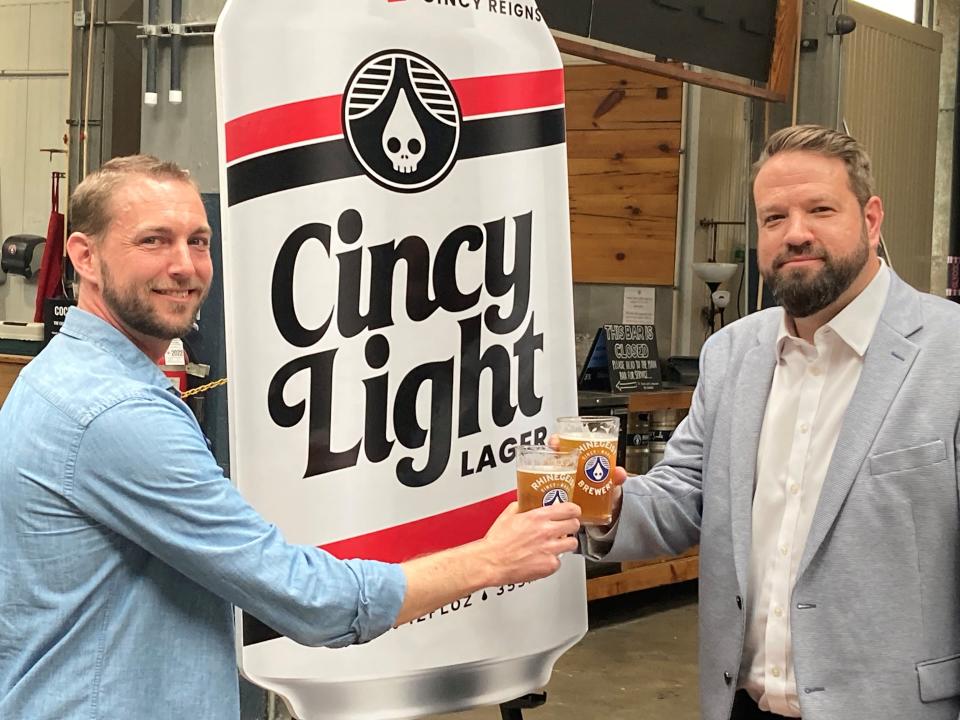 Rhinegeist interim CEO Adam Banovich, left and Cincy Reigns Chair of Board of Directors Brian Fox toast their new collaboration to help the NIL collective, Cincy Light.