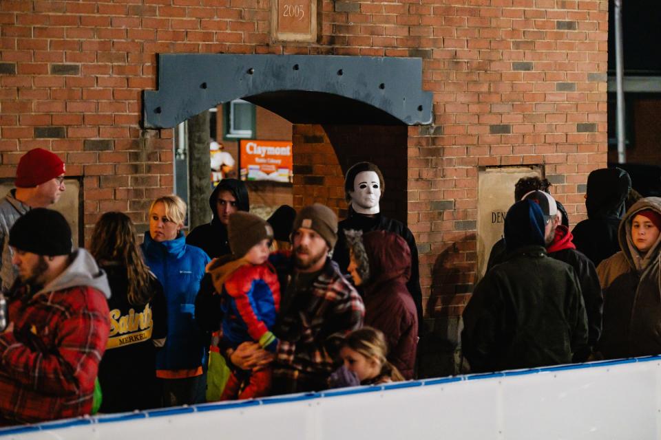 People wait in line to rent skates during the preview night for the new outdoor skating rink in Dennison.