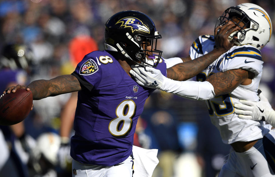 <p>Baltimore Ravens quarterback Lamar Jackson (8) tries to break free from Los Angeles Chargers free safety Derwin James in the first half of an NFL wild card playoff football game, Sunday, Jan. 6, 2019, in Baltimore. (AP Photo/Nick Wass) </p>