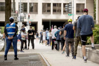 People wear masks as they wait in line to vote at a voting center during primary voting in Washington, Tuesday, June 2, 2020. (AP Photo/Andrew Harnik)