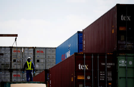 FILE PHOTO: A man works to load a container on a truck at an industrial port in Tokyo, Japan, February 22, 2019. Picture taken on February 22, 2019. REUTERS/Kim Kyung-hoon/File Photo GLOBAL BUSINESS WEEK AHEAD