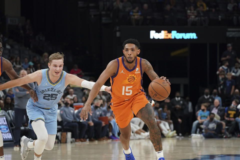 Phoenix Suns' Cameron Payne (15), heads for the basket as Memphis Grizzlies' Mikal Bridges (25) defends in the second half of an NBA basketball game Friday, Nov. 12, 2021, in Memphis, Tenn. (AP Photo/Karen Pulfer Focht)