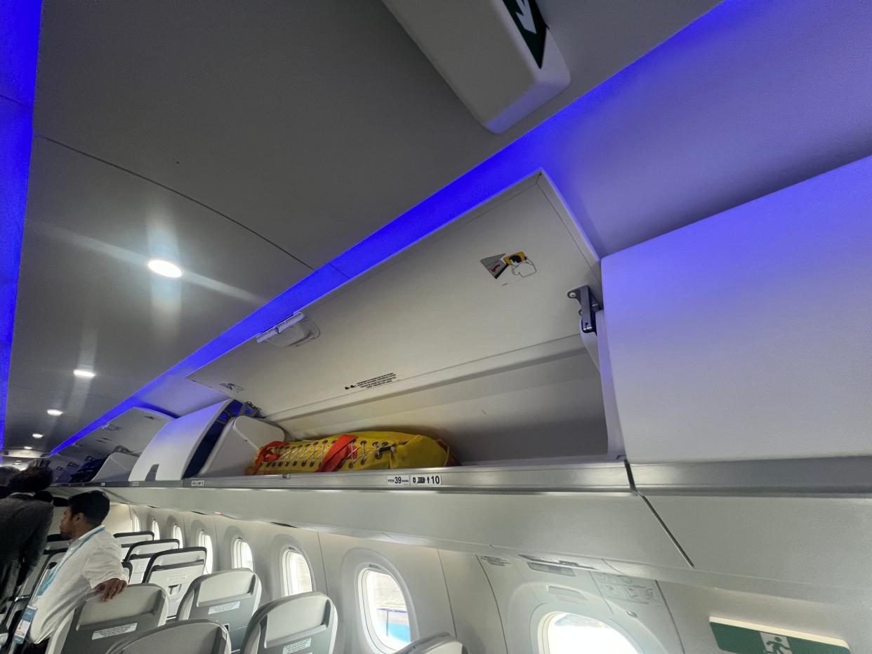 An open overhead bin on board an Embraer E195-E2 at the 2024 Farnborough Airshow