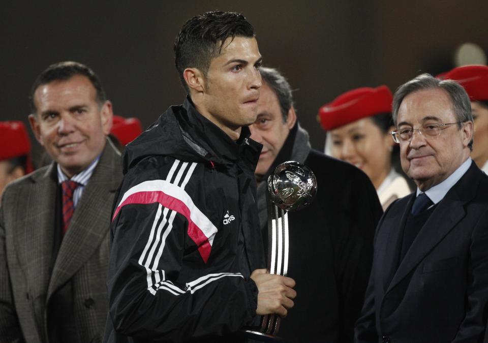 Cristiano Ronaldo, con trofeo en mano, le pasa al frente al francés Michel Platini. (AP Photo/Christophe Ena)