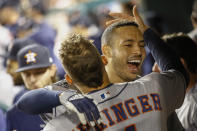 Houston Astros' Carlos Correa celebrates in the dugout with George Springer after his two-run home run against the Washington Nationals during the fourth inning of Game 5 of the baseball World Series Sunday, Oct. 27, 2019, in Washington. (AP Photo/Patrick Semansky)