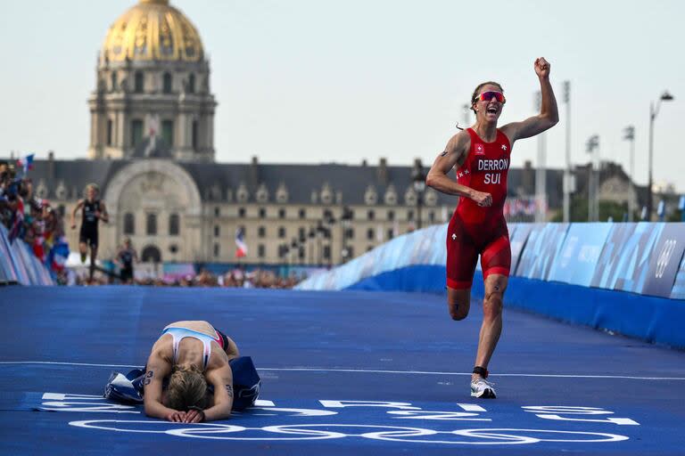 La francesa Cassandre Beaugrand  se desploma después de cruzar en primer lugar; festeja la suiza Julie Derron en el puente Alexandre III, al final de la carrera de triatlón individual femenino 