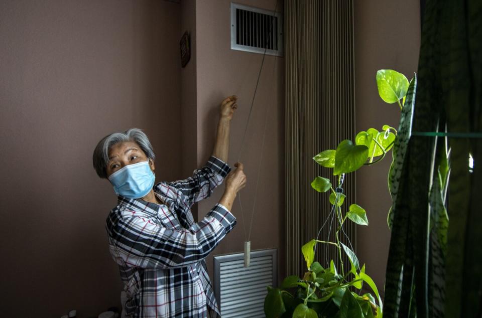 Amy Chun stands in the living room of her fourth-floor Cathy Manor apartment.