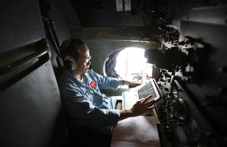 Military officer Duong Van Lanh works within a Vietnamese airforce AN-26 during a mission to find the missing Malaysia Airlines flight MH370 off Tho Chu islands March 11, 2014. REUTERS/Kham