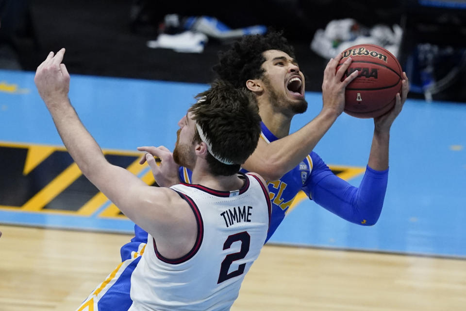 UCLA guard Johnny Juzang, rear, drives to the basket over Gonzaga forward Drew Timme (2) during the second half of a men's Final Four NCAA college basketball tournament semifinal game, Saturday, April 3, 2021, at Lucas Oil Stadium in Indianapolis. Juzang was called for charging. (AP Photo/Darron Cummings)